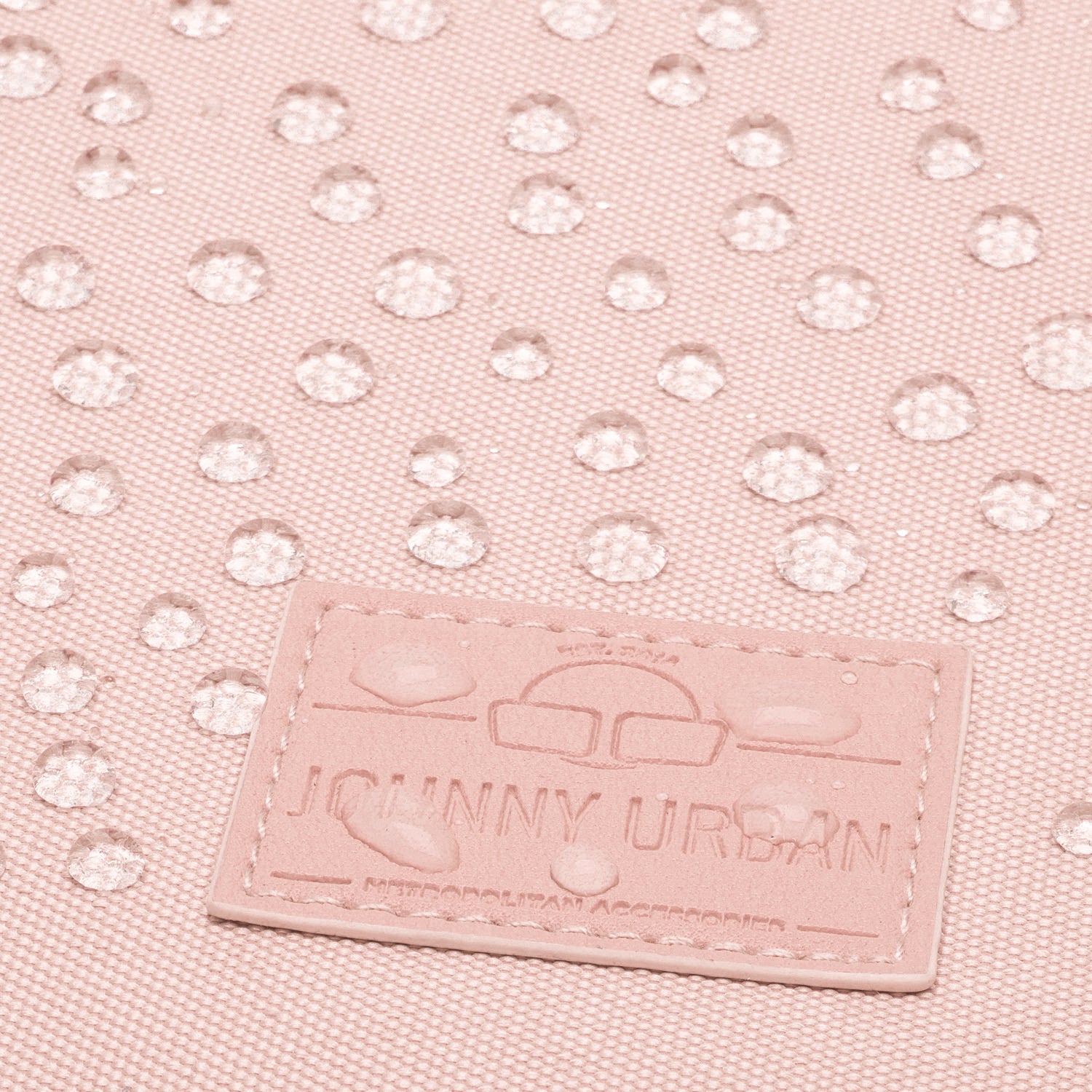 Nahaufnahme eines rosafarbenen wasserabweisenden Rucksackstoffs mit Johnny Urban Markenetikett