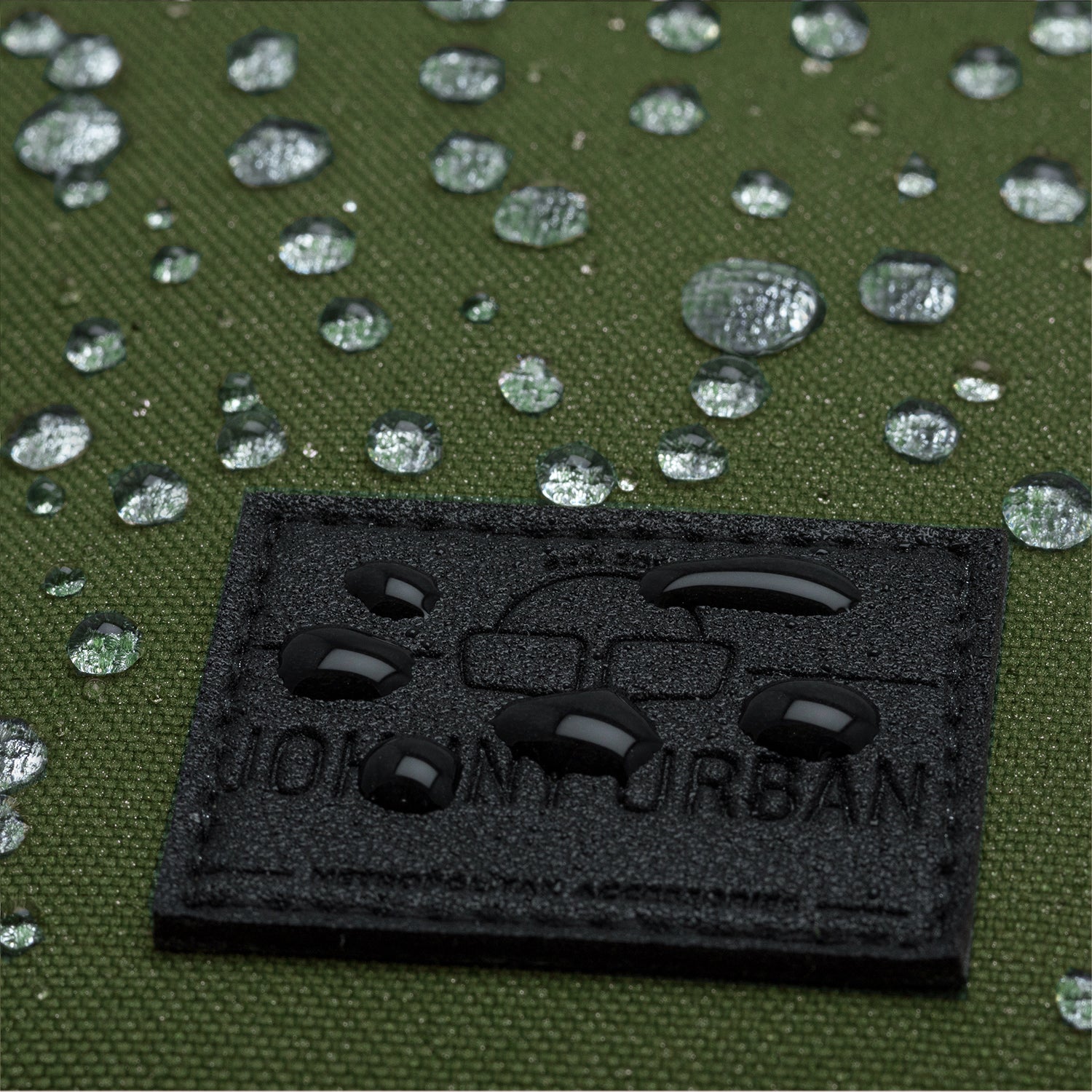 Wasserabweisender grüner Rucksackstoff mit Johnny Urban Logo und Wassertröpfchen