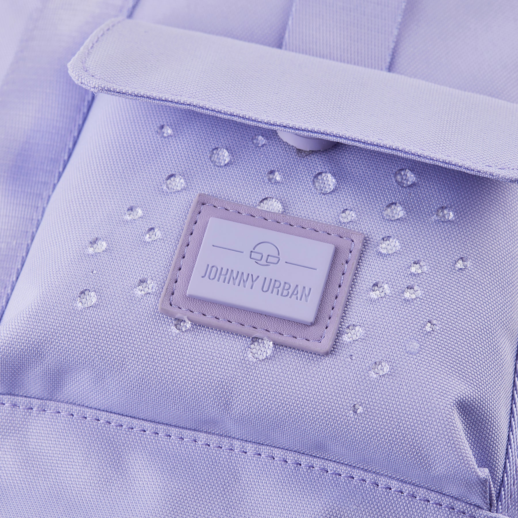 Nahaufnahme des lila Johnny Urban Rucksacks 'Jules' mit sichtbaren Wassertropfen auf dem Material