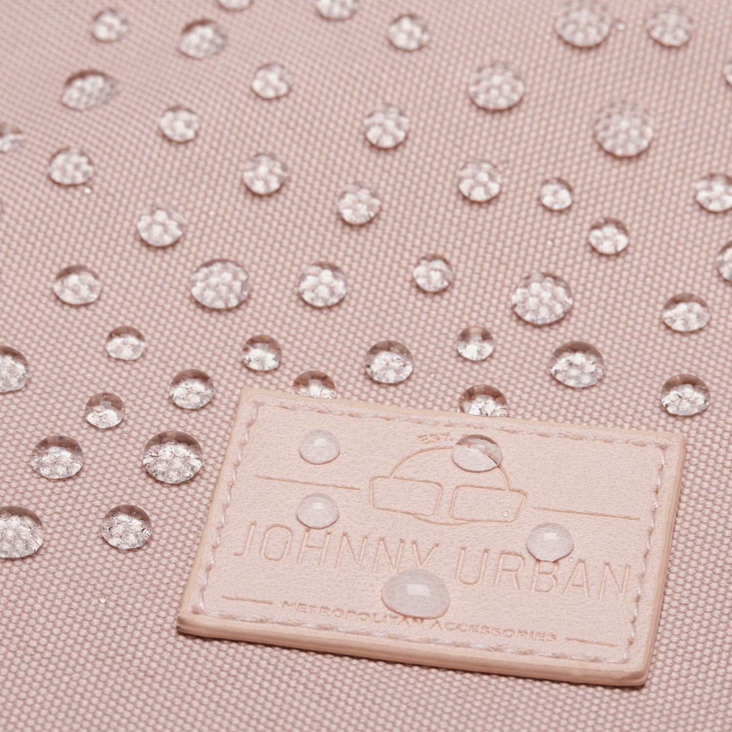 Wassertropfen auf rosafarbenem, wasserdichtem Stoff des Rucksacks 'Milo' von Johnny Urban