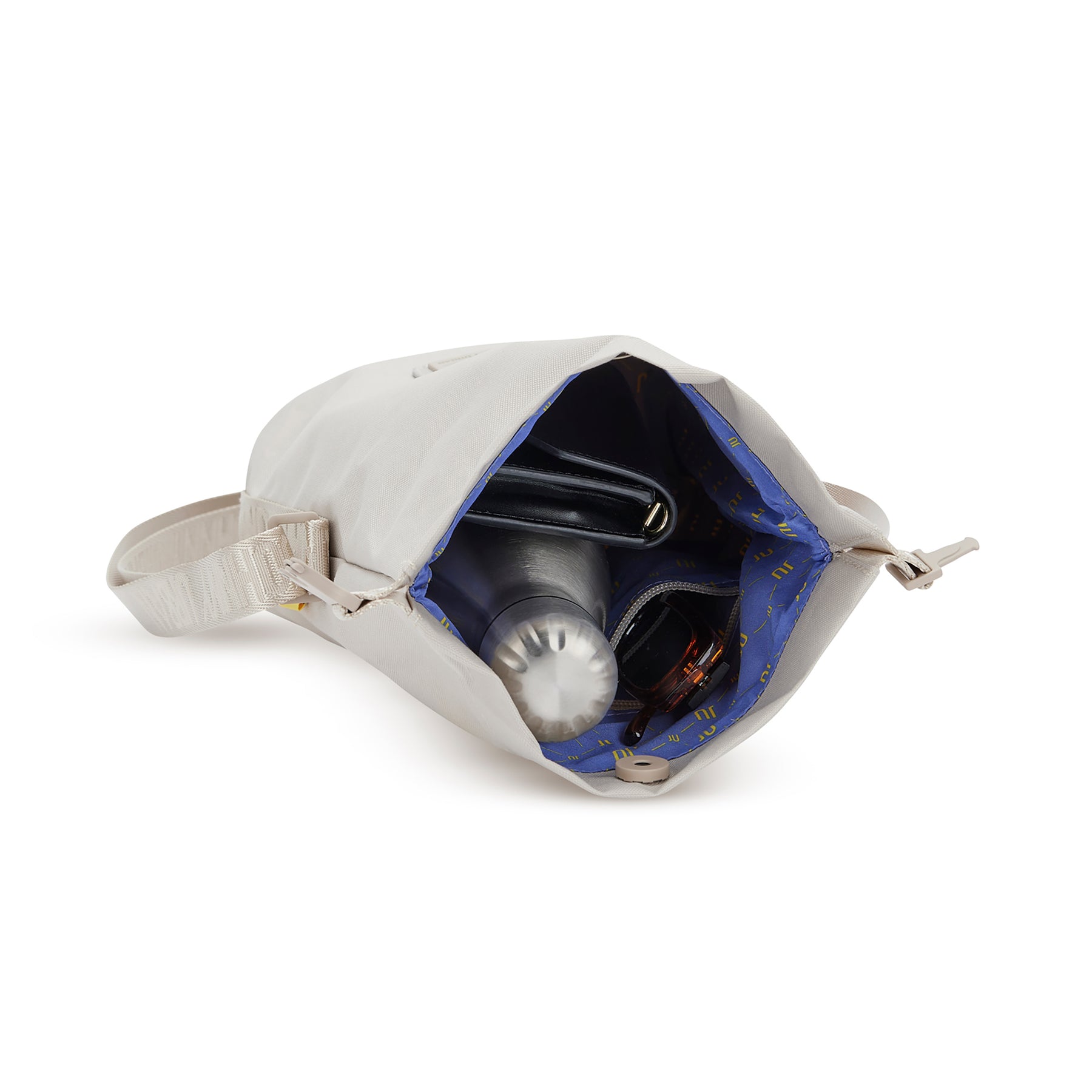 Beige Umhängetasche 'Rue' von Johnny Urban mit blauem Innenfutter, geöffnet und teils gefüllt mit Wasserflasche, schwarzer Geldbörse und Schlüsselbund