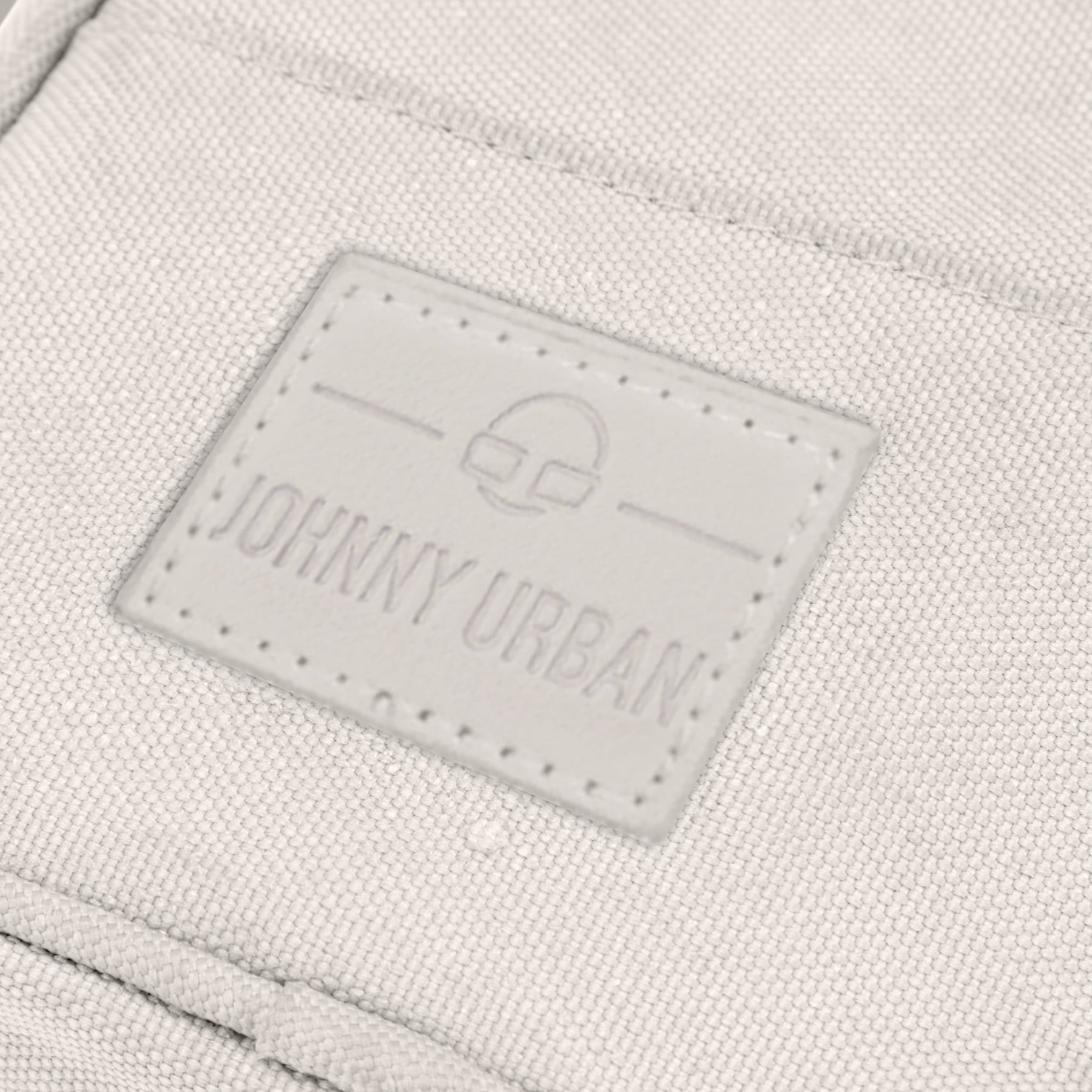 Nahe Aufnahme des Johnny Urban Logos auf der sandfarbenen Umhängetasche 'Josh'