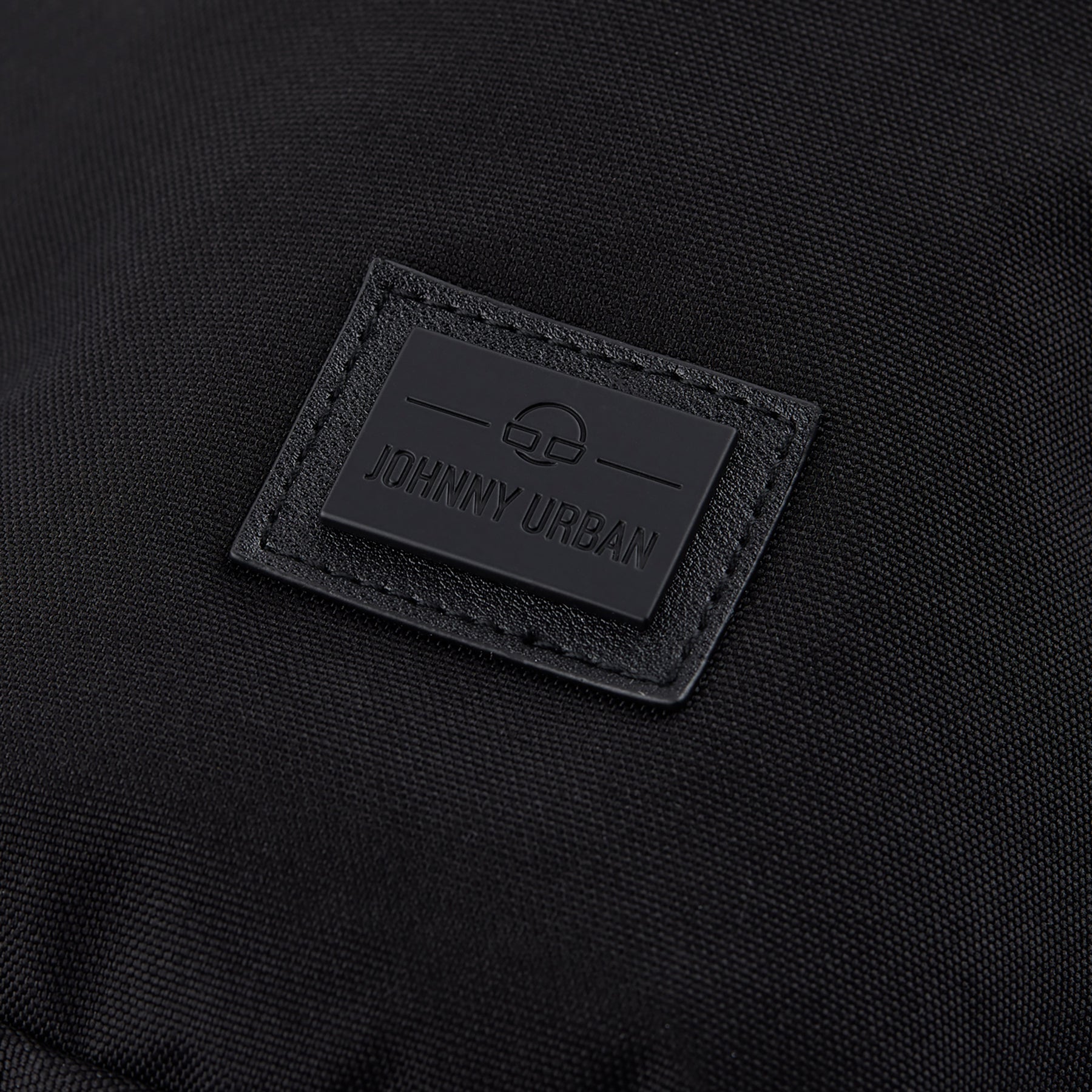 Schwarzes Logoetikett mit Schriftzug 'Johnny Urban' auf nachhaltiger Umhängetasche 'Rue'