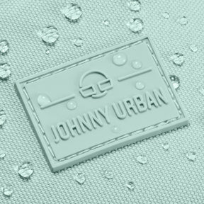 Nahaufnahme des wasserabweisenden Johnny Urban Logos auf der mintfarbenen Bauchtasche 'Erik Large' mit Wassertropfen