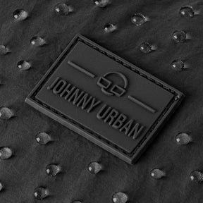 Nahaufnahme des Johnny Urban Logos auf wasserabweisendem, schwarzem Stoff mit Wassertröpfchen