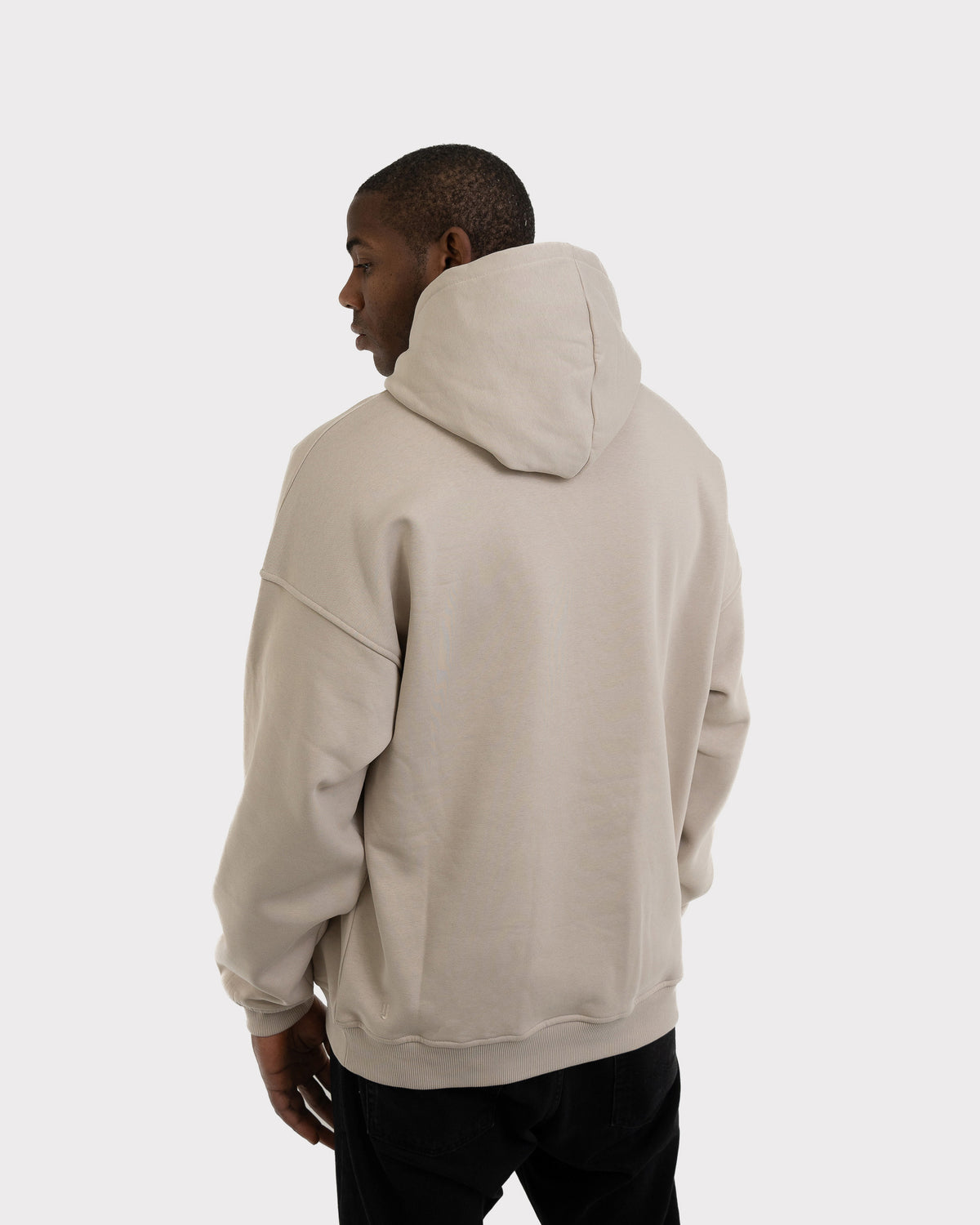 Mann trägt oversized Hoodie 'Cody' in Hellgrau von hinten