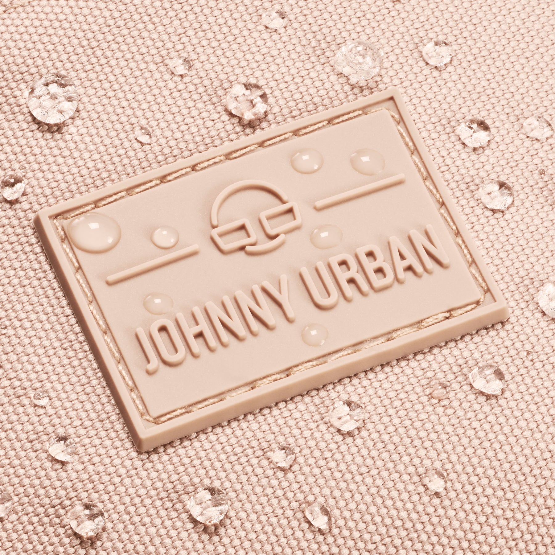 Nahaufnahme des Johnny Urban Logos auf der rosafarbenen Bauchtasche Erik Large mit Wasserperlen