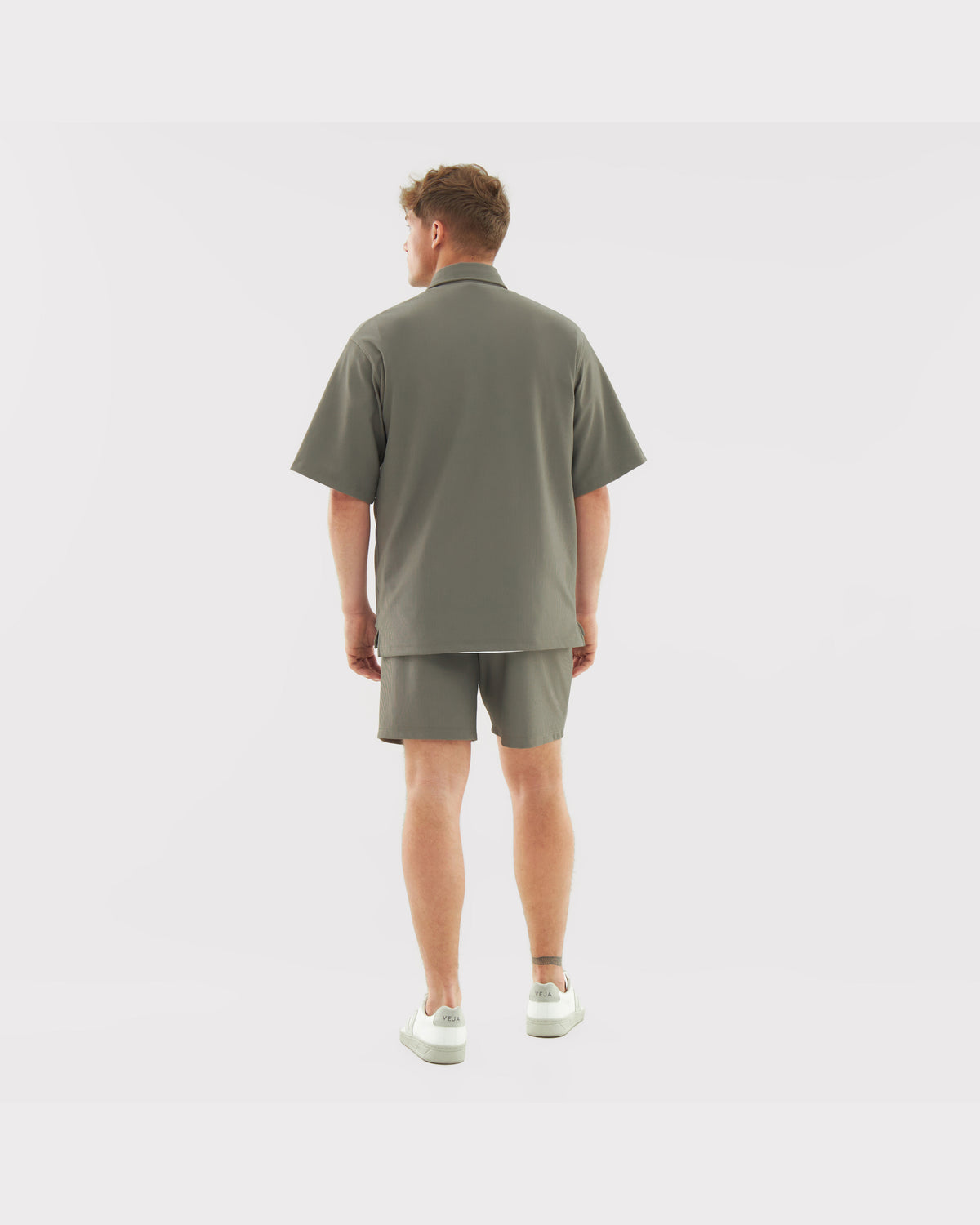 Männliches Model von hinten mit olivfarbenen lockeren Shorts "Mason" und passendem Hemd
