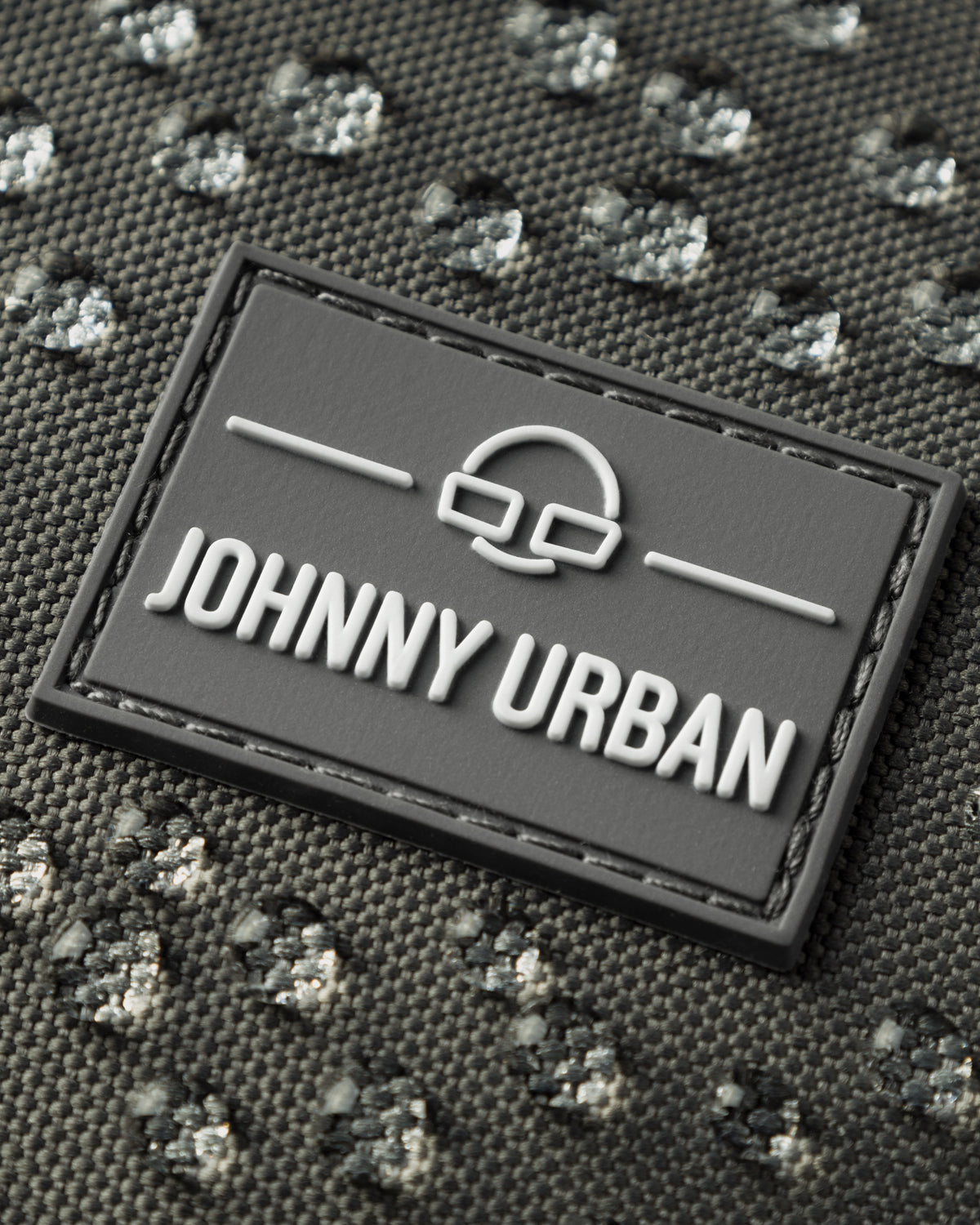 Nahaufnahme des wasserabweisenden Materials und Markenlabels der Half Moon Bag 'Ally Medium' von Johnny Urban