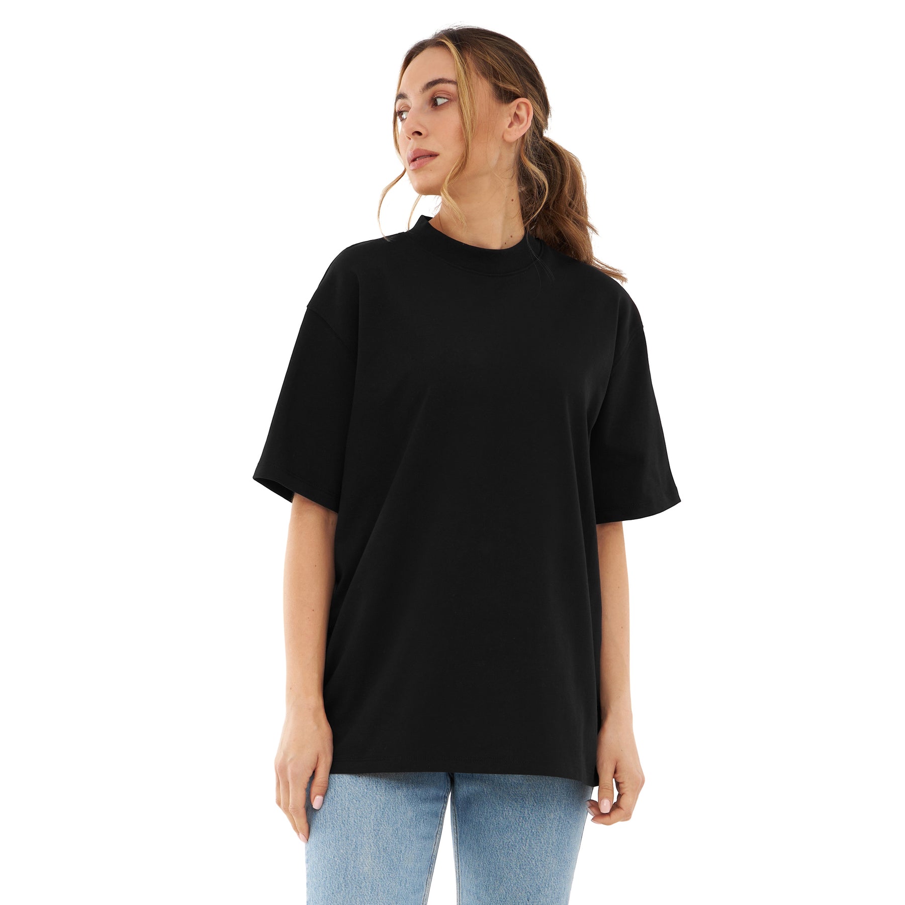Frau trägt schwarzes Oversize-T-Shirt ohne Aufdruck und blaue Jeans