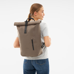 Beiger wasserfester Rolltop Rucksack 'Conor' von Johnny Urban auf dem Rücken einer Frau