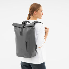 Frau trägt grauen wasserdichten Rolltop Rucksack 'Conor' von Johnny Urban mit schwarzem Verschluss