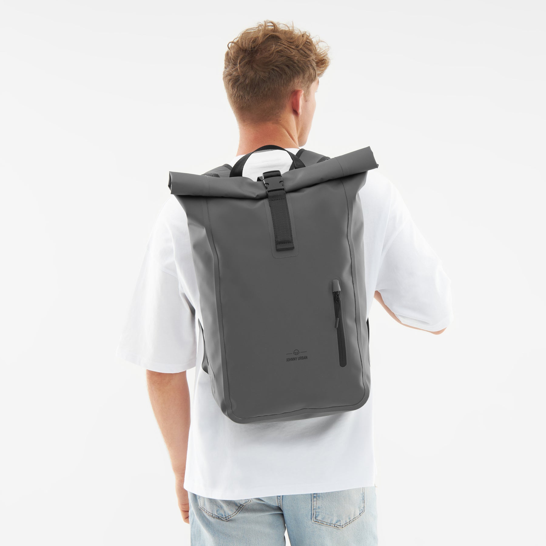 Mann mit weißem T-Shirt trägt grauen, wasserfesten Rolltop Rucksack 'Conor' von Johnny Urban