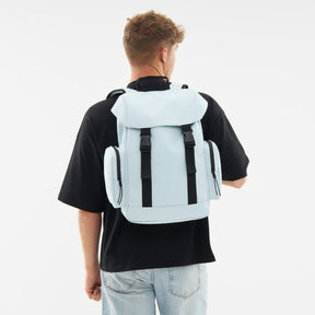 Hellblauer Rucksack 'Finley' mit zwei seitlichen Reißverschlusstaschen, getragen von einem Mann in schwarzem T-Shirt und hellen Jeans