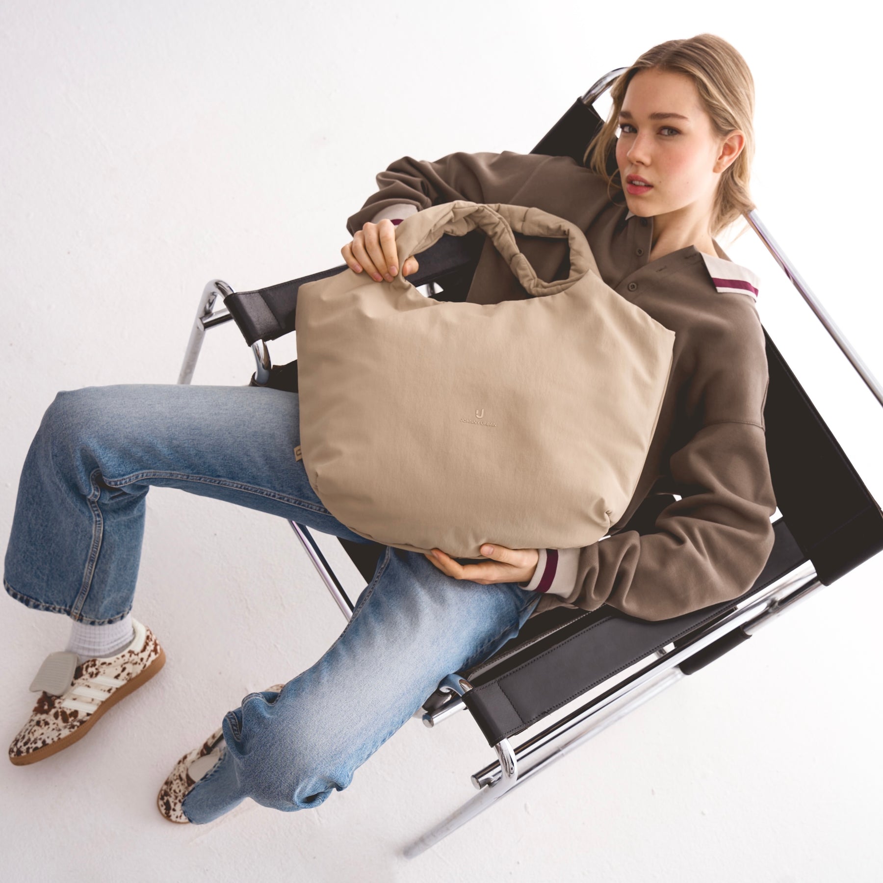 Unser weibliches Model präsentiert hier die Shopper-Tote-Bag "Cleo" in beige. 