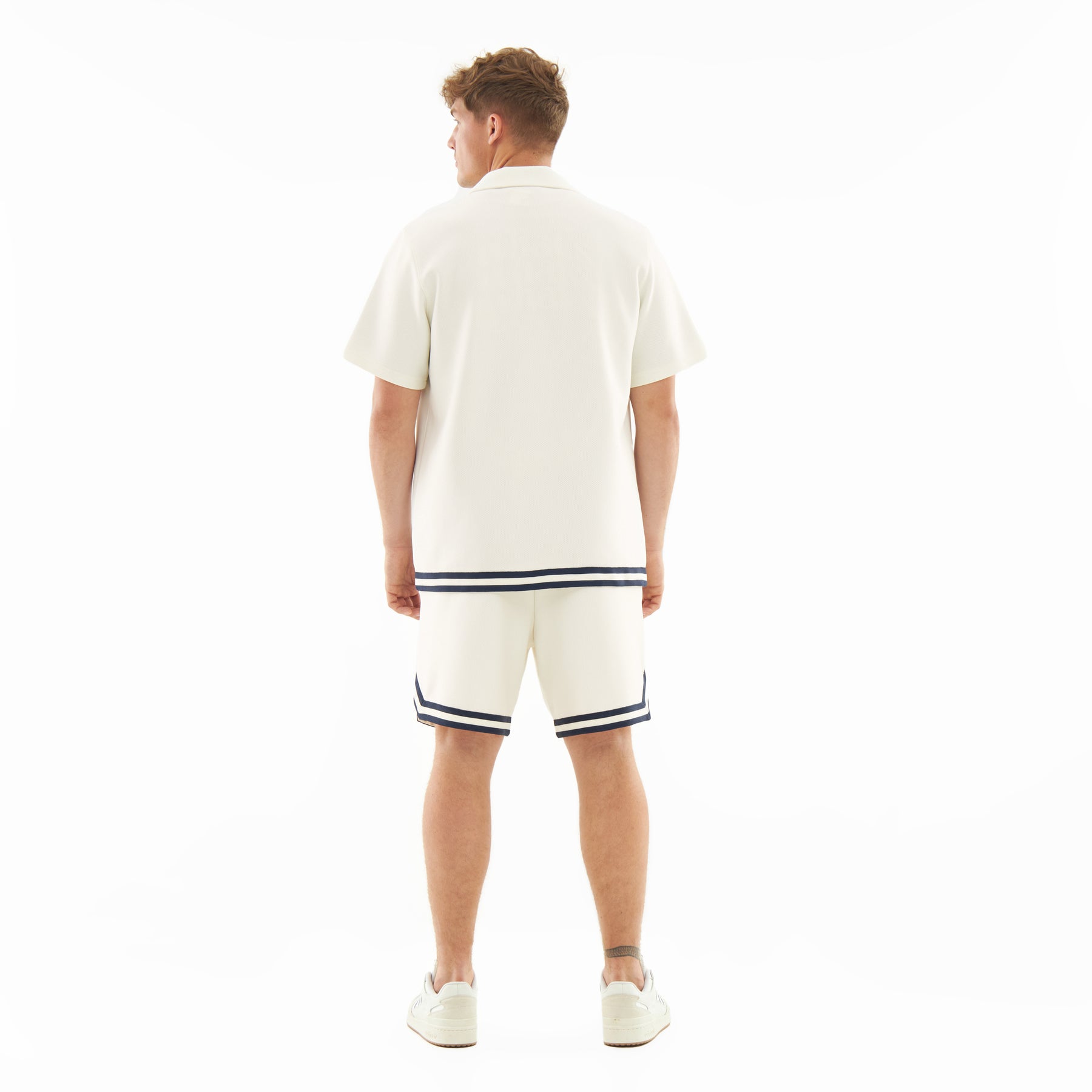 Mann von hinten in cremefarbenen Shorts 'Parker' mit dunklen Streifen am Saum