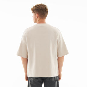 Mann von hinten trägt T-Shirt 'Vic' in Creme mit lockerem Schnitt und kurzen Ärmeln