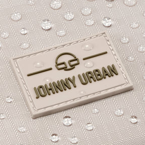 Nahaufnahme des wasserabweisenden beigefarbenen Stoffs mit 'Johnny Urban' Logo auf Umhängetasche Jayden