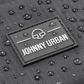 Nahaufnahme des Johnny Urban Logos auf grauem, wasserabweisendem Stoff mit Wassertropfen