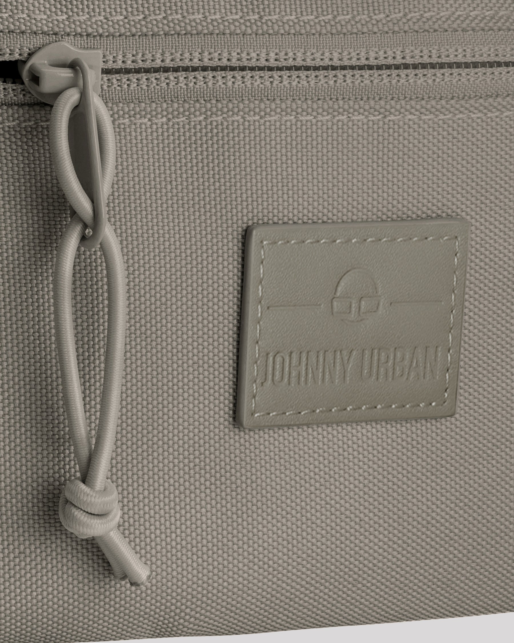 Detailansicht der Naht, des Reißverschlusses und des Logos der Johnny Urban Bauchtasche 'Erik Small' in desert grey