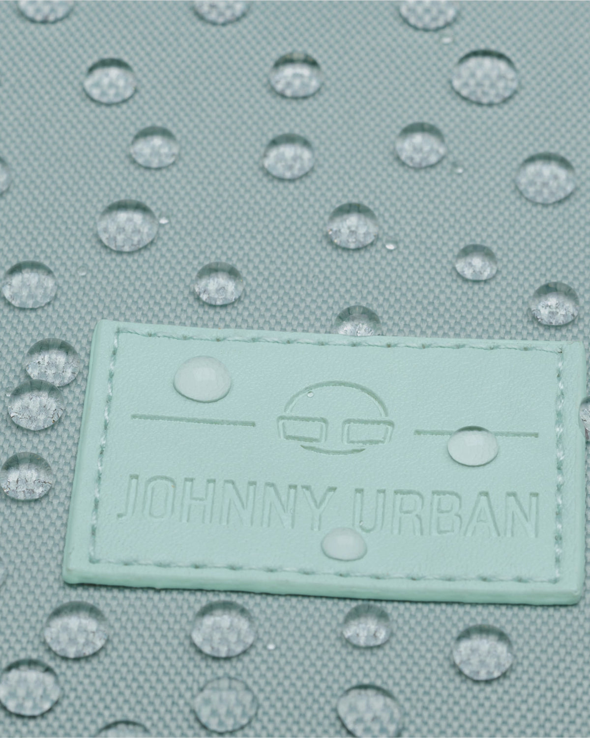 Mintfarbener Stoff des Rolltop Rucksacks 'Robin Small' mit wasserabweisender Beschichtung und Johnny Urban Logo