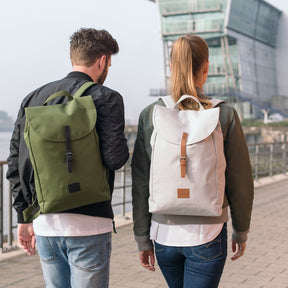 Zwei Personen von hinten mit Rucksack 'Liam', grün und grau, beim Gehen am Ufer