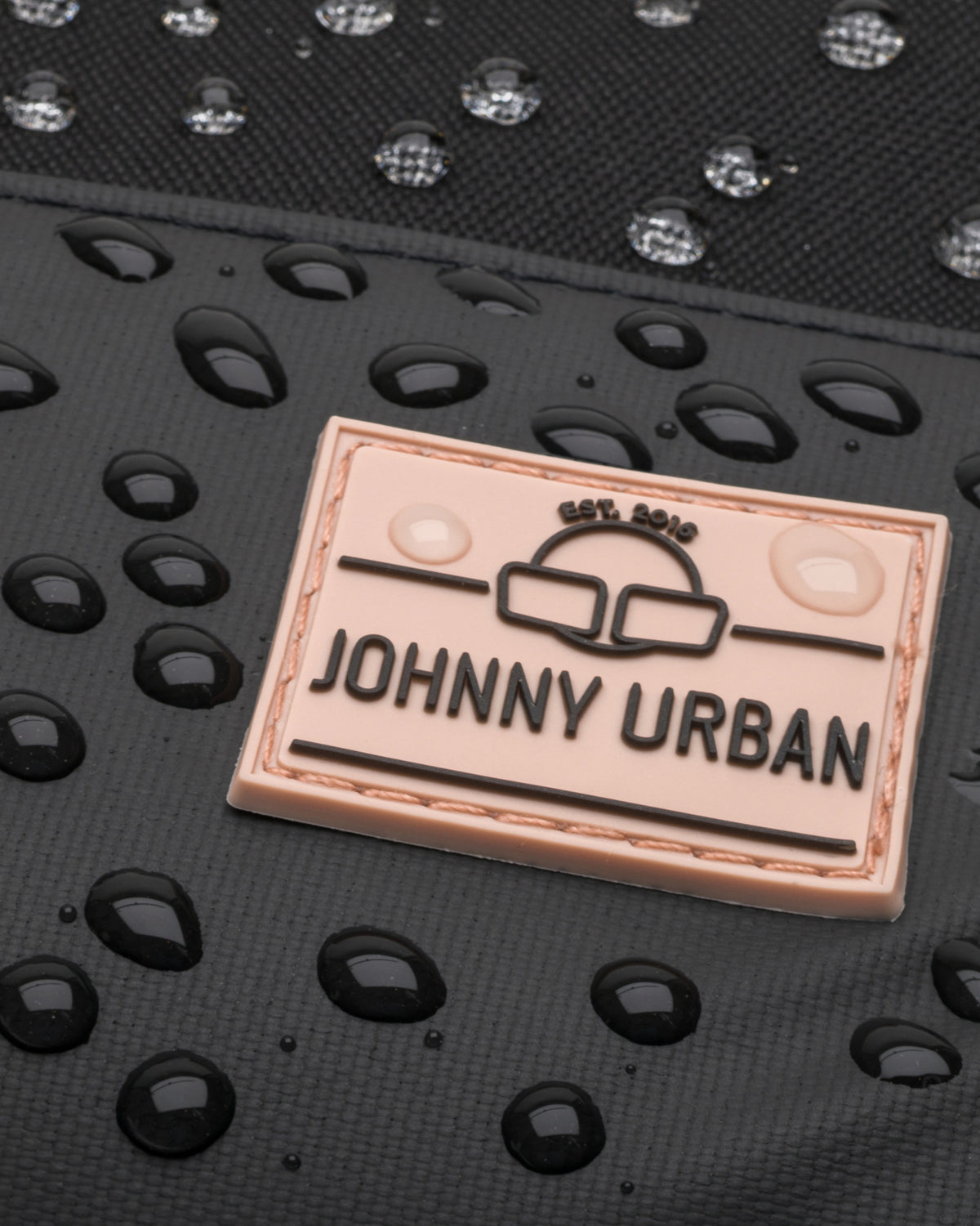 Nahaufnahme eines wasserdichten Johnny Urban Rucksacks "Mika" mit Wassertröpfchen auf der Oberfläche