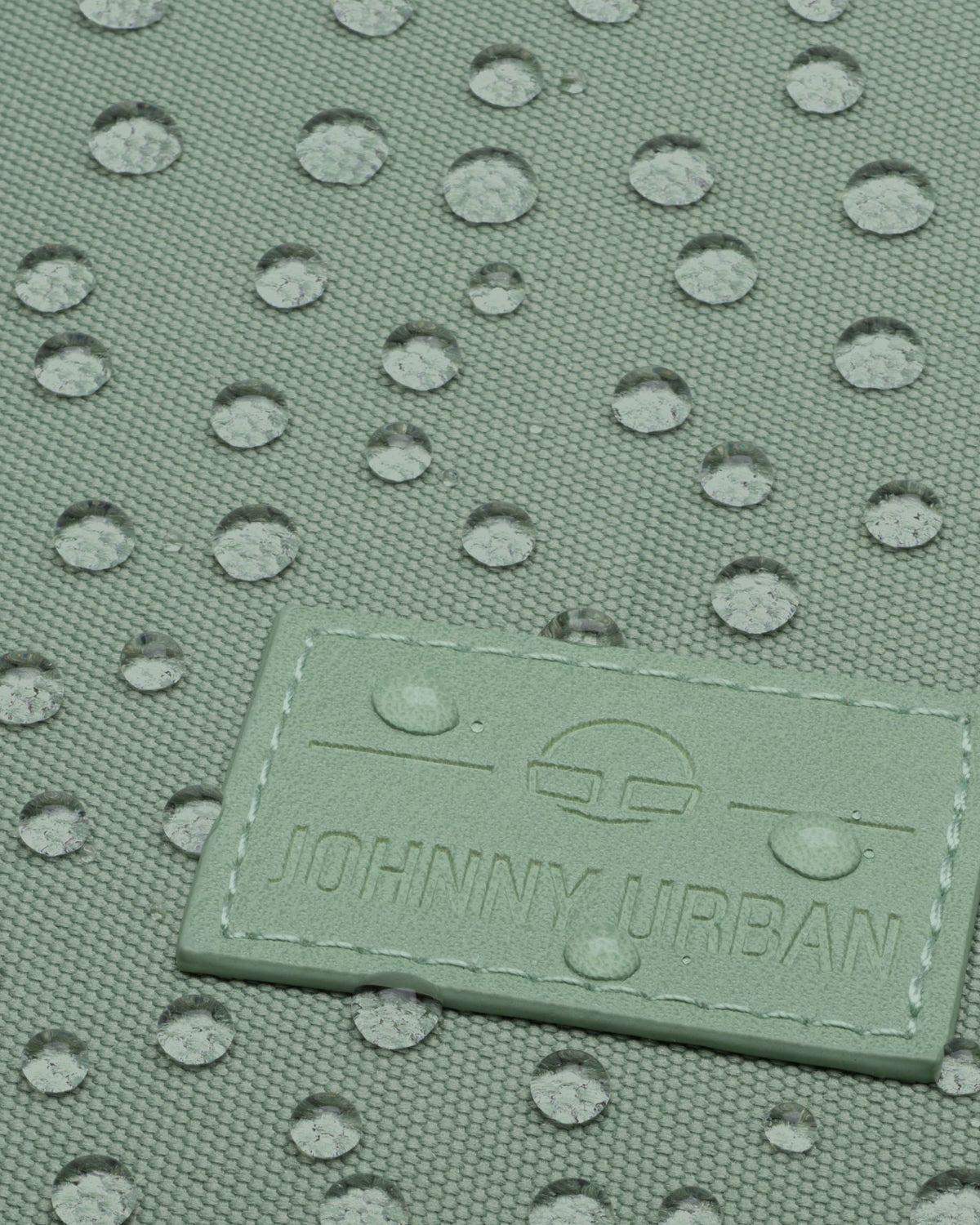 Grüner wasserabweisender Stoff mit 'Johnny Urban' Markenlabel und Wassertropfen